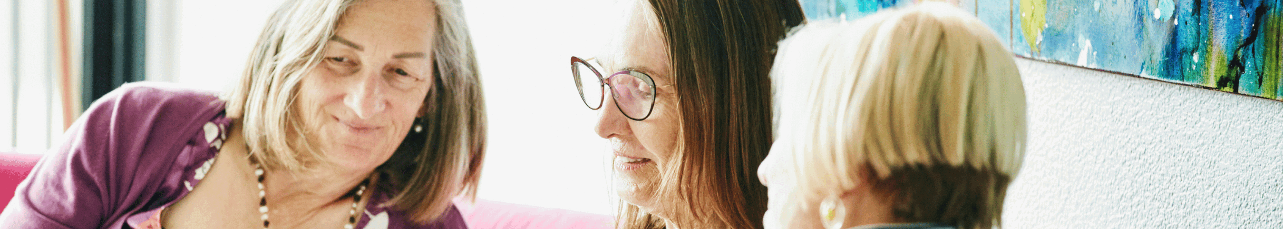 friends sitting on a couch looking at information on a phone