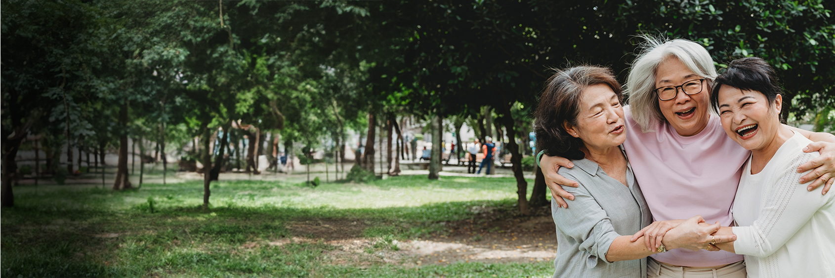Three women standing together smiling with their arms around each other