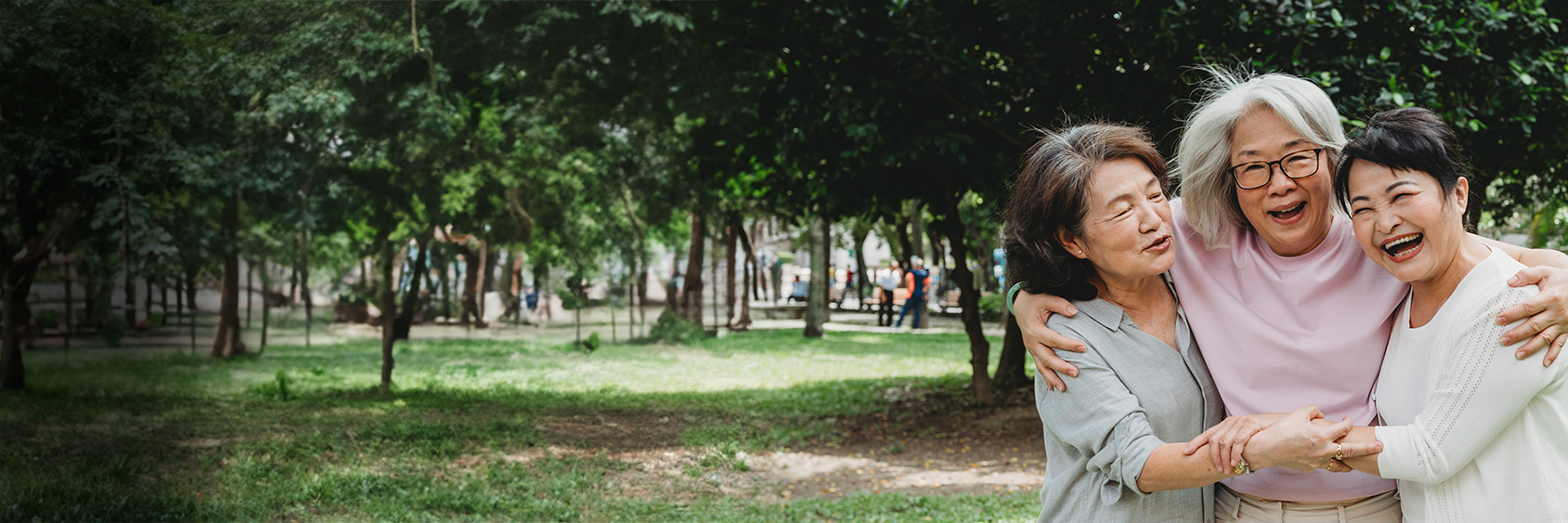 Three women standing together smiling with their arms around each other